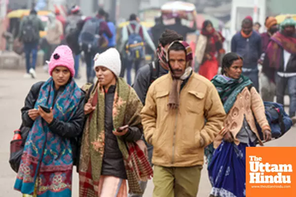 Lucknow: Commuters wearing warm clothes walk past Charbagh railway station on a cold winter day