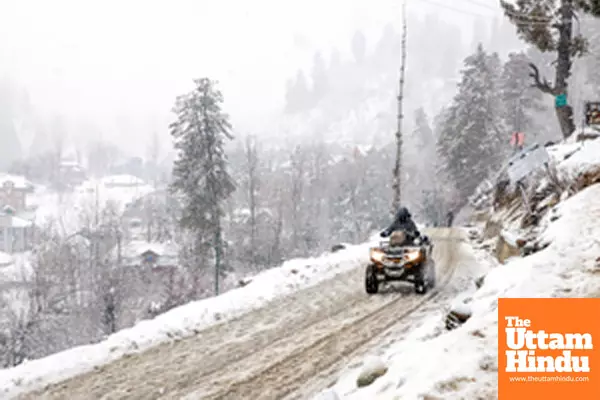 Baramulla: A person rides an all-terrain vehicle on a snow-covered road amid heavy snowfall