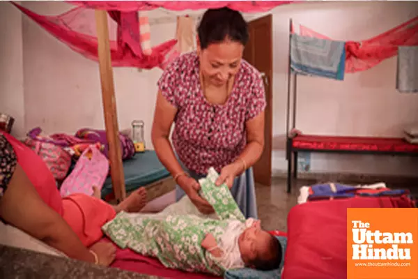 Bishnupur: A new mother cares for her baby at a relief camp