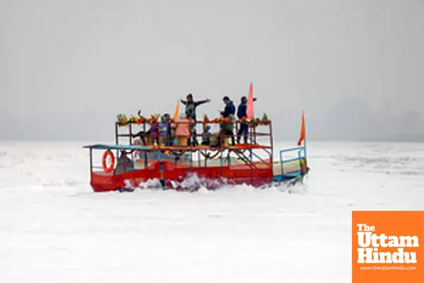 Mathura: People ride a boat through toxic foam floating on the polluted Yamuna river