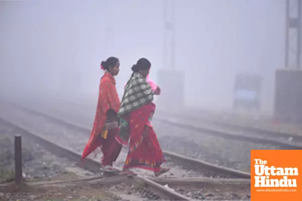 Nagaon: Women cross railway tracks amid dense fog on a cold winter morning