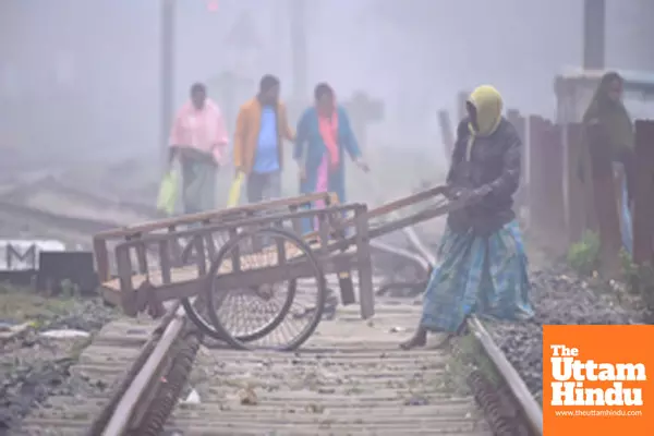 Nagaon: A man with his cart tries to cross railway tracks amid dense fog on a cold winter morning