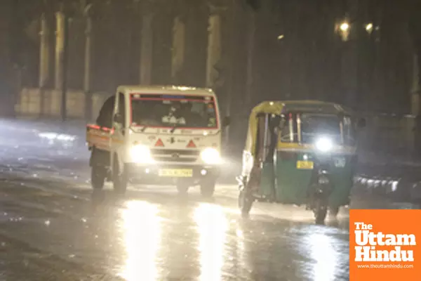 New Delhi : Vehicles pass through the streets amid rainfall