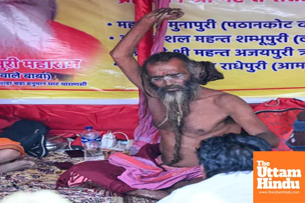 Prayagraj: A Sadhu (Holy Man) with his hands raised in the air sitting at his camp