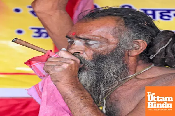 Prayagraj: A Sadhu (Holy Man) smokes a chillum, at his camp on the banks of the Sangam