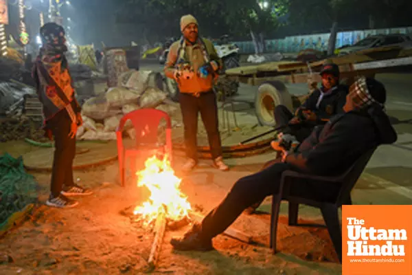 Prayagraj: People sit around a bonfire to keep themselves warm on a cold morning