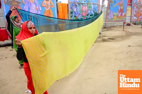 Prayagraj: Devotees dry their saree after taking a holy dip at the Triveni Sangam