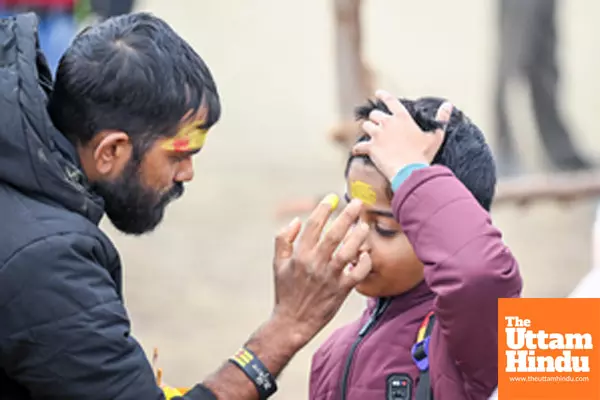 Prayagraj: A man applies Tilak to a child at the Triveni Sangam,