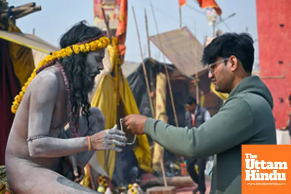 Prayagraj: A Naga Sadhu (Holy Man) ties sacred thread to a man after taking a holy dip at the Triveni Sangam