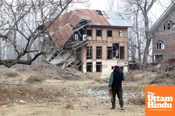 Baramulla: A security personnel stands guard outside a destroyed house at Malmooh village