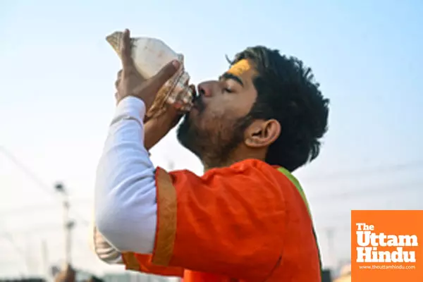 Prayagraj: A priest blows a shankh (conch shell) at Triveni Sangam