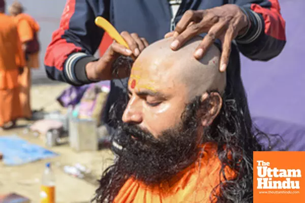 Prayagraj: A sadhu gets his head shaved at a camp during the Maha Kumbh Mela