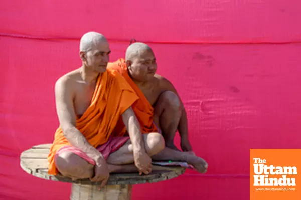 Prayagraj: Monks dressed in saffron robes sit together at a camp during the Maha Kumbh Mela