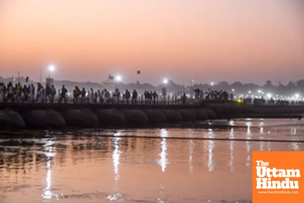 Prayagraj: Pilgrims walk across a pontoon bridge in the evening during the Maha Kumbh Mela