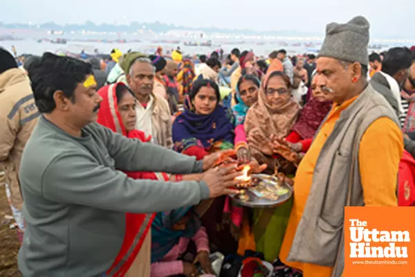 Prayagraj: A priest offers aarti to devotees at Triveni Sangam