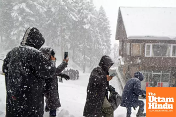 Baramulla: People walk on a snow-covered road as heavy snowfall