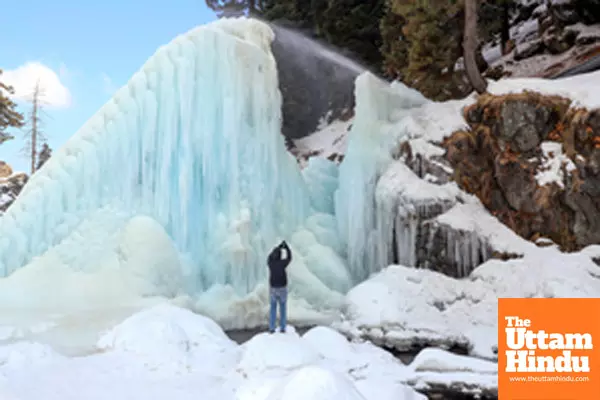 Baramulla: A tourist clicks a picture of a huge icicle