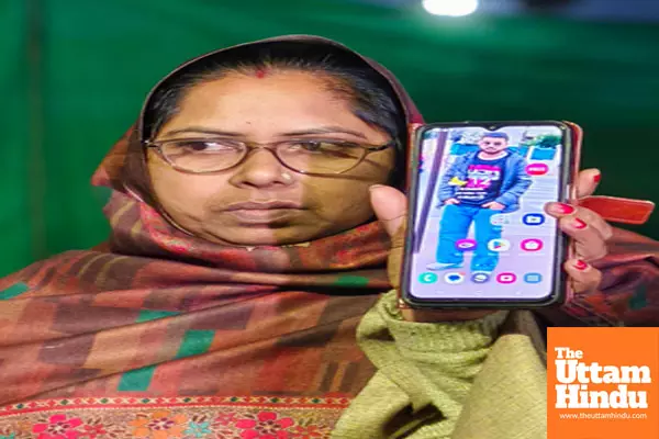 A woman holds a phone displaying a photo of a relative, among the Indian immigrants deported from the US