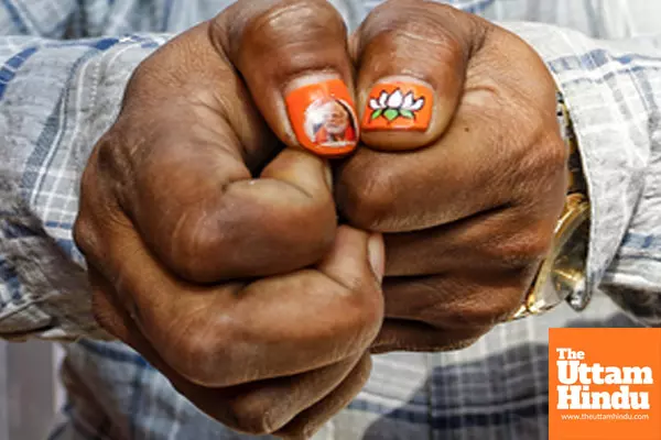 A BJP supporter flaunts nail art painted with the BJP flag